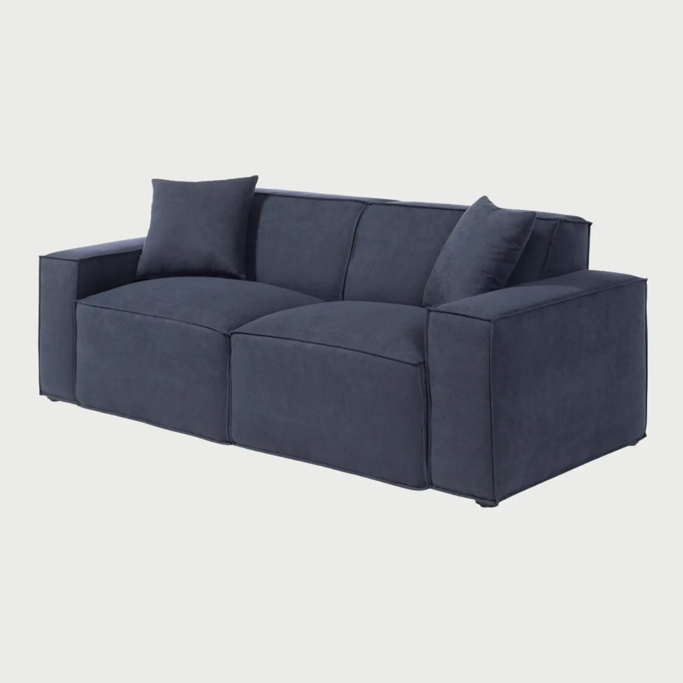 Vista lateral del sofá Otto azul, que muestra su perfil bajo y robusto con descansabrazos anchos y cuadrados que se extienden hasta la base, reforzando su estética moderna y minimalista.