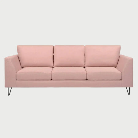 Vista frontal del sofá Yoco de tres cuerpos en color rosa, mostrando una estética contemporánea y suave con cojines mullidos y estructura de soporte minimalista.