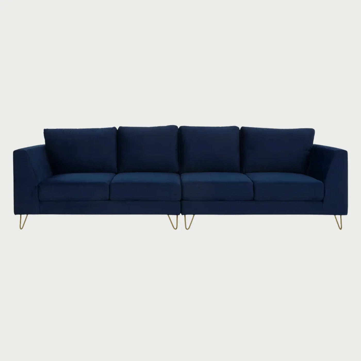 Vista frontal del sofá Yoco de cuatro plazas tapizado en terciopelo azul marino, con cuatro cojines de respaldo y asiento individuales, elevado sobre elegantes patas metálicas tipo horquilla en acabado dorado.