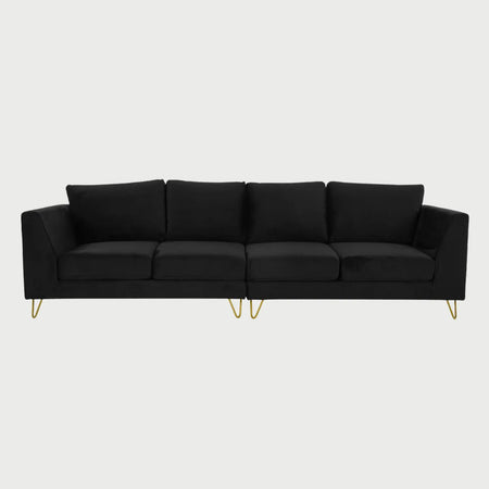 Vista frontal del sofá Yoco de cuatro plazas en terciopelo negro, resaltando una estética sofisticada y moderna con un contraste marcado entre el tejido oscuro y el metal dorado.
