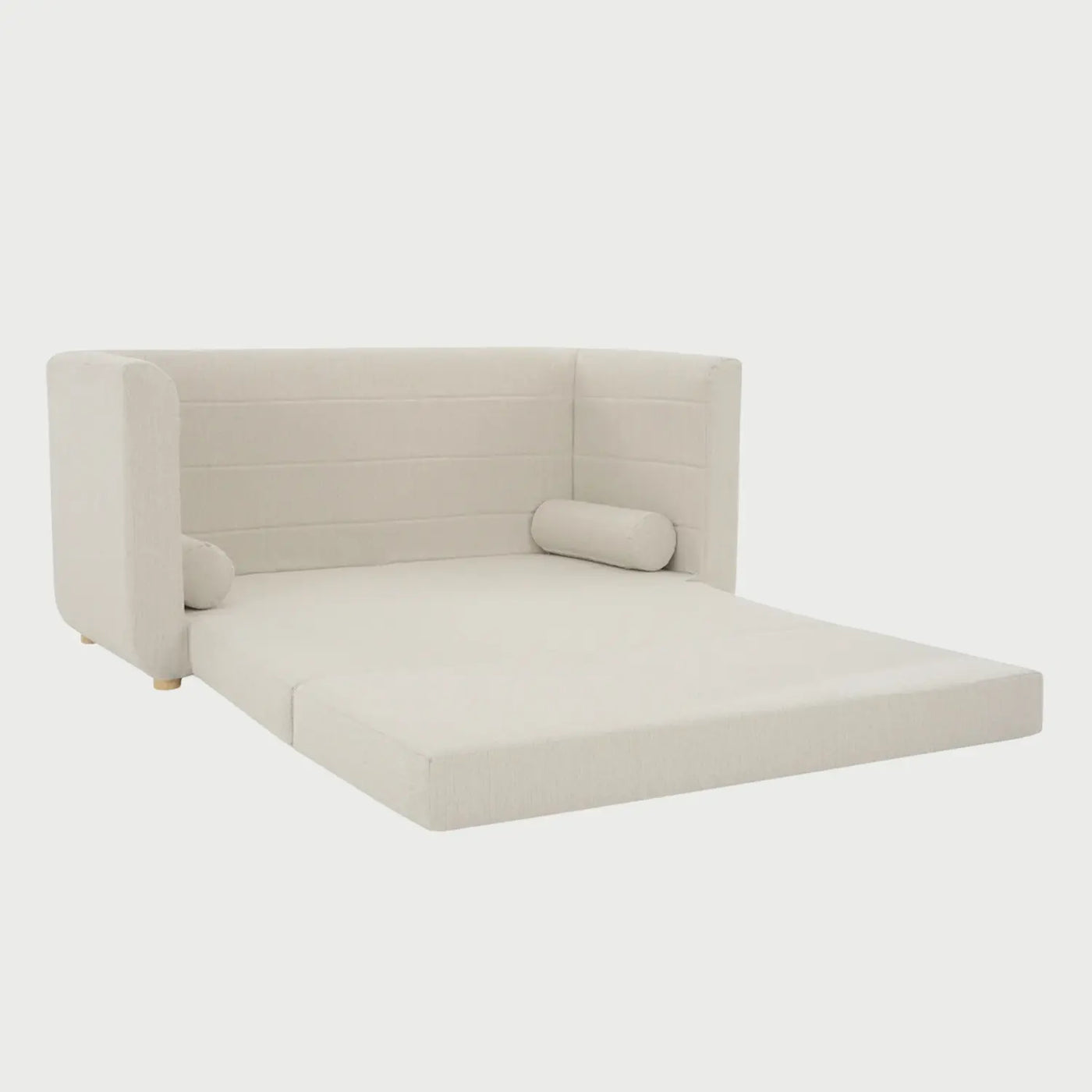 Vista lateral del sofá cama Basil blanco, resaltando el perfil redondeado de los brazos y la base elevada sobre patas de madera clara barnizada.