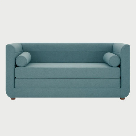 Vista frontal del sofá cama Basil en color verde, mostrando su silueta moderna y el soporte estructural de madera con acabado nogal.