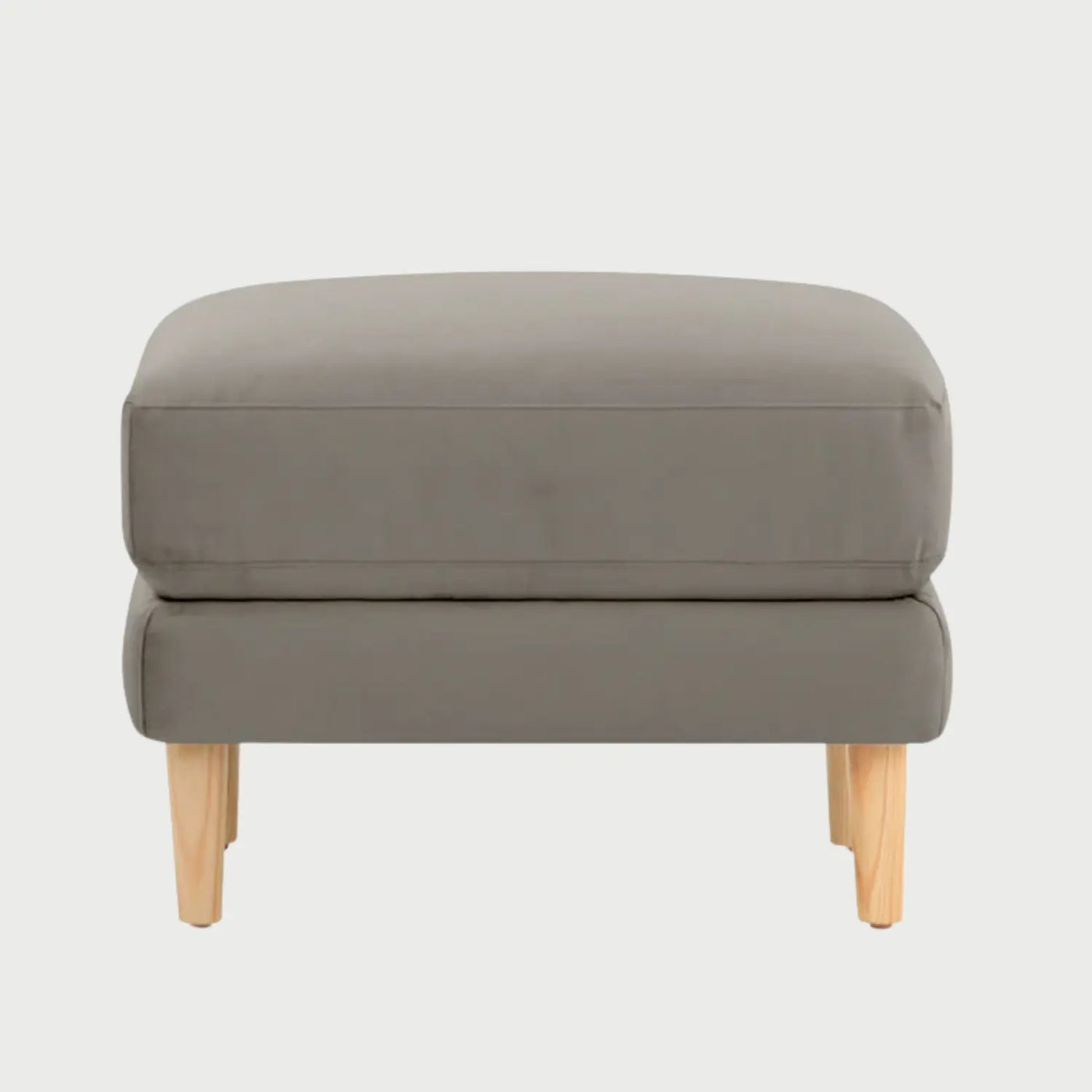Vista frontal del taburete Levanto en color beige, con un diseño de cojín superior acolchado de bordes rectos y base elevada sobre patas de madera clara en acabado encino.