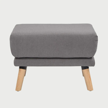 Vista frontal del taburete San Blas en color gris, destacando su silueta funcional y moderna con patas de madera clara de inspiración contemporánea.