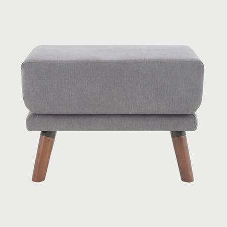 Vista frontal del taburete San Blas en color gris, destacando su diseño minimalista y el contraste sofisticado de la tela con las patas oscuras de nogal.