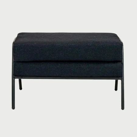 Vista frontal del taburete Tuxama en color negro, destacando su apariencia monocromática y sofisticada con cojines de doble nivel y estructura de patas a juego.