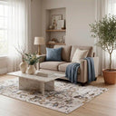 Rug rectangular con patrones abstractos, colocado sobre un suelo de madera, junto a un sofá y elementos decorativos. Tapete Sirku de GAIA.