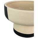Maceta redonda de diseño bicolor, con parte superior clara y base negra, ideal para decorar tu espacio.