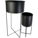 Juego de 2 maceteros Ureña en color negro, con soportes metálicos, uno más alto y otro más bajo, perfectos para decorar tu espacio.