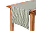 Camino de mesa GAIA con diseño de cuadros chicos en verde y blanco, elegantemente dispuesto sobre una mesa de madera.