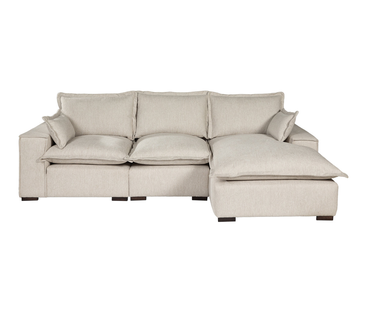 Sofá modular esquinero derecho en color marfil con múltiples cojines y sección de chaise lounge, diseño moderno y patas de madera.