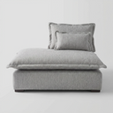 Módulo central con banca izquierda Emilia en tela gris, con cojines grandes y decorativos, ideal para salas modernas.