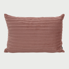 Cojín rectangular en color rosa suave, con superficie texturizada y bordes redondeados, ideal para decorar cualquier espacio.