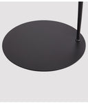 Base circular negra de la lámpara de piso Pluma, con un diseño esbelto y minimalista, ideal para espacios contemporáneos.