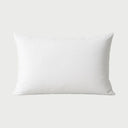 Vista frontal de la almohada Premium firme; su construcción de alta densidad en color blanco ofrece un soporte cervical reforzado, manteniendo una superficie lisa y elegante con detalles satinados.