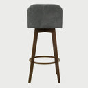 Vista posterior del banco alto Leco en color gris, resaltando el acabado continuo del tapizado en el respaldo y la sólida estructura de unión de las patas de madera.