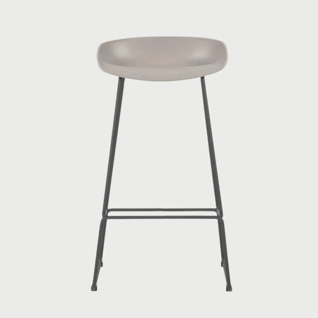 Vista frontal del banco alto Morel en color beige, con un asiento ergonómico de perfil bajo y bordes curvos, sostenido por una estructura esbelta de cuatro patas metálicas en color gris oscuro con reposapiés integrado.