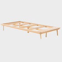 Vista lateral de base de cama individual Sei mostrando altura y patas de madera