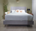 Cama queen size Skye en color azul, con un juego de ropa de cama clara y almohadas decorativas, en un ambiente moderno y acogedor.
