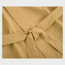 Acercamiento al cuello y hombro de la bata Vanti beige; se observa la calidad de las costuras reforzadas y la textura suave del algodón, ideal para una experiencia de spa en casa.