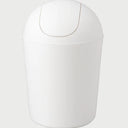 Vista frontal del bote de basura Olem en color blanco sólido; presenta un diseño cilíndrico minimalista con una tapa de domo que incluye un sistema de vaivén para un desecho higiénico.