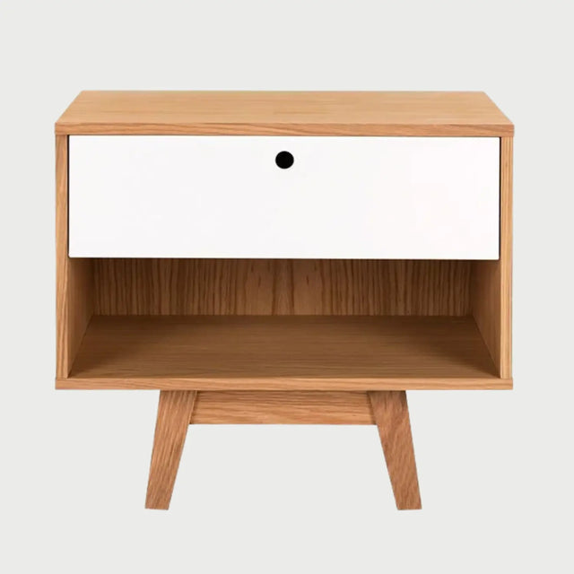 Vista frontal del buró Evo con estructura en acabado encino natural, un cajón superior en color blanco mate con tirador circular y un nicho inferior abierto sobre patas de madera inclinadas.