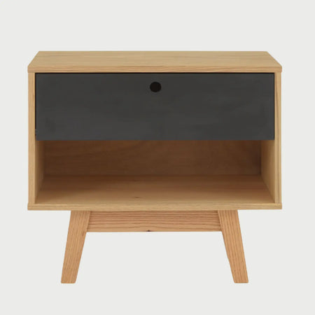 Vista frontal del buró Evo en acabado negro mate, que cuenta con un cajón superior con tirador circular tipo uñero y un nicho de almacenamiento abierto en la parte inferior sobre patas inclinadas.