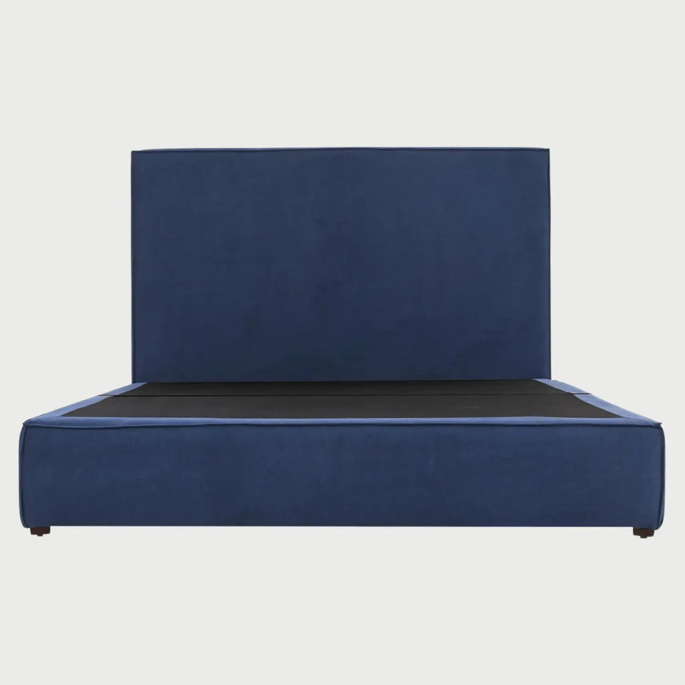 Vista frontal de la cama King Size Raquel; destaca por su cabecera extra ancha y rectangular tapizada en tela azul profundo, integrada a una base de perfil bajo que proyecta un diseño de bloque sólido y minimalista.