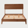Vista frontal de la cama matrimonial Akari; presenta una estructura de madera con acabado nogal en tono café, destacando una cabecera rectangular de bordes suavizados y una base de perfil bajo con patas angulares discretas.
