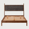 Vista frontal de la cama matrimonial Ami; destaca su cabecera de madera en acabado nogal con un tejido artesanal de cinchos de piel café oscuro entrelazados, creando un patrón de cuadrícula elegante sobre una base de madera sólida.