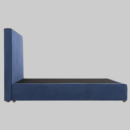 Detalle del marco inferior de la cama Raquel en color azul; se aprecia el diseño de perfil bajo que descansa sobre soportes casi invisibles, enfatizando un efecto de bloque sólido y minimalista.