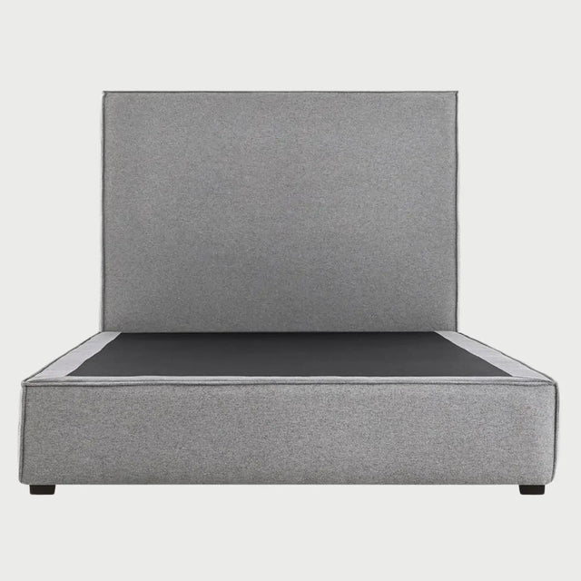 Vista frontal de la cama matrimonial Raquel en color gris medio; ofrece un equilibrio visual perfecto que destaca la estructura envolvente de la base y la altura de su respaldo liso.