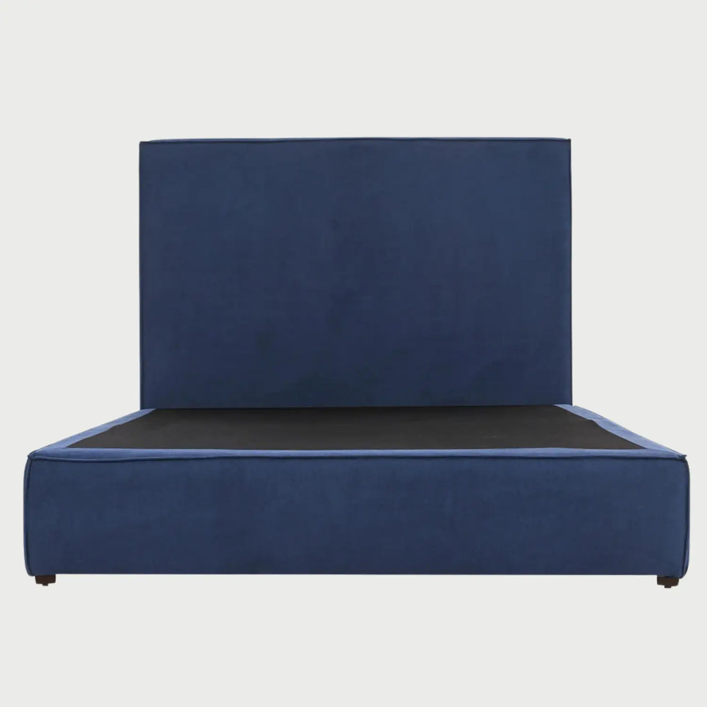 Vista frontal de la cama Queen Size Raquel; presenta una cabecera alta y rectangular tapizada en terciopelo azul profundo con una base de perfil bajo a juego que oculta los soportes, ofreciendo una estética moderna y lujosa.