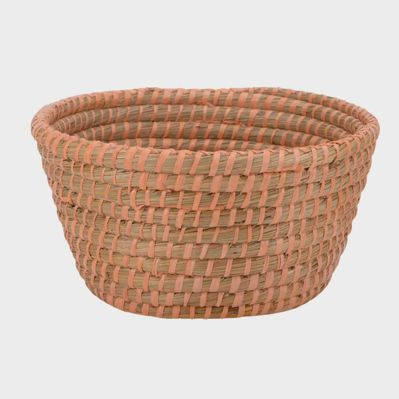 Vista frontal de la canasta grande Damu con detalles en color naranja; el hilo vibrante contrasta con la paja clara, aportando una estética cálida y artesanal al diseño de almacenamiento circular.