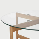 Vista en perspectiva del centro de mesa Acuna; resalta la transparencia de la cubierta que permite visualizar completamente la veta natural de la madera y el ensamble de la base de soporte.