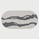 Vista frontal superior de la charola grande Mistle; presenta una forma ovalada alargada compuesta por dos piezas simétricas en concreto blanco, decoradas con vetas fluidas en color gris oscuro que emulan el mármol natural.