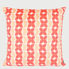 Vista frontal del cojín cuadrado Bonelo de 43 x 43 cm; presenta un patrón repetitivo de formas florales estilizadas de cuatro pétalos en color rojo coral y salmón suave, dispuestas en franjas verticales sobre un fondo crema claro.