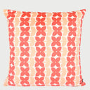 Vista frontal del cojín cuadrado Bonelo de 43 x 43 cm; presenta un patrón repetitivo de formas florales estilizadas de cuatro pétalos en color rojo coral y salmón suave, dispuestas en franjas verticales sobre un fondo crema claro.