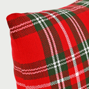 Acercamiento al textil del cojín Cobijo; se observa la trama detallada del algodón tejido donde se cruzan los hilos rojos, verdes y blancos, resaltando la textura acogedora y la calidad del acabado del patrón tartán.