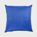 Vista frontal del cojín cuadrado Cosmo de 50 x 50 cm; presenta un fondo textil en color azul rey vibrante salpicado de un patrón denso de puntos blancos irregulares, simulando un cielo estrellado o polvo cósmico.