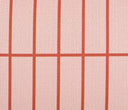 Acercamiento al textil del cojín Neima; muestra la trama cerrada de la tela y la precisión de las líneas naranjas que forman la cuadrícula, junto con la etiqueta lateral negra de GAIA que certifica su diseño exclusivo.