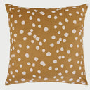 Vista frontal del cojín cuadrado Puntos de 50 x 50 cm; presenta un fondo de color ocre cálido decorado con un patrón irregular de motas o puntos blancos de bordes suaves, creando un efecto visual orgánico y acogedor similar a un estampado animal natural.