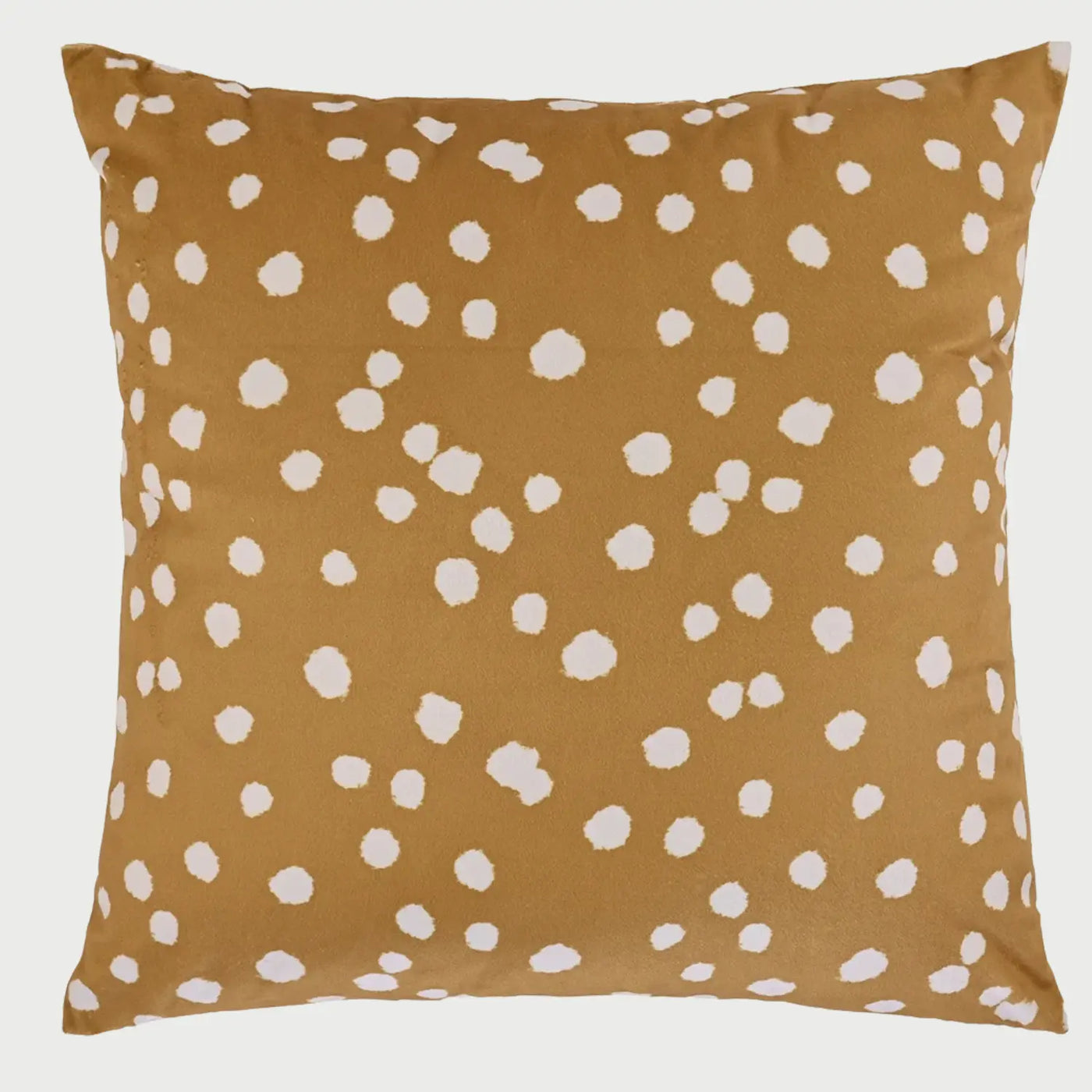Vista frontal del cojín cuadrado Puntos de 50 x 50 cm; presenta un fondo de color ocre cálido decorado con un patrón irregular de motas o puntos blancos de bordes suaves, creando un efecto visual orgánico y acogedor similar a un estampado animal natural.