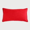 Vista frontal del cojín rectangular Víspera de 30 x 50 cm; fabricado en lana de color rojo intenso, destaca por su superficie lisa y un ribete decorativo bicolor en blanco y negro que recorre todo su perímetro.