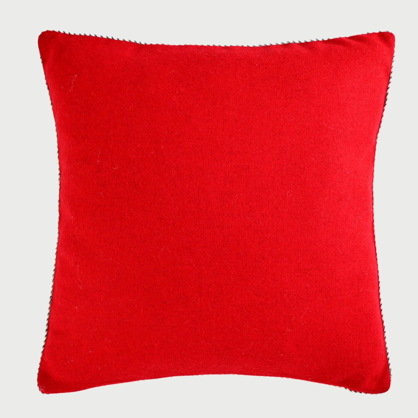 Vista frontal del cojín cuadrado Víspera de 45 x 45 cm; confeccionado en lana de color rojo intenso, resalta por su diseño liso enmarcado por un ribete perimetral bicolor en blanco y negro que le otorga un acabado definido y elegante.