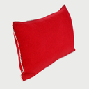 Vista lateral del cojín Víspera rojo; se observa su perfil ergonómico con un relleno acolchado ideal para soporte lumbar, resaltando el detalle del cordón trenzado en el borde que aporta un contraste elegante.