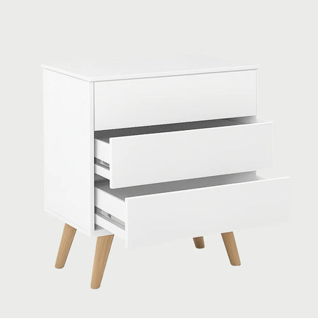 Vista lateral de la cómoda Cuauhtémoc blanca, que muestra la profundidad de su cuerpo rectangular y el diseño estilizado de la base de madera que sobresale sutilmente.