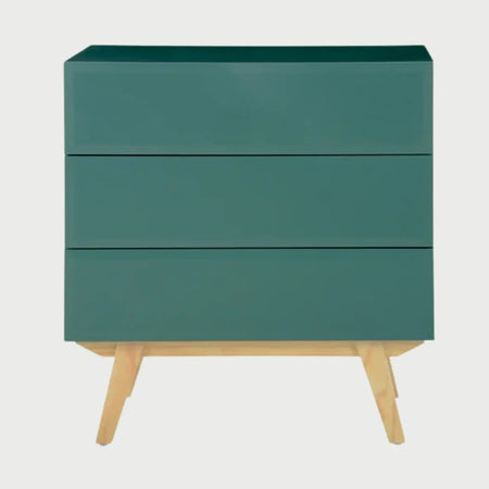Vista frontal de la cómoda Cuauhtémoc en acabado verde mate, destacando la simetría de sus tres cajones biselados y el contraste con las patas de madera natural.