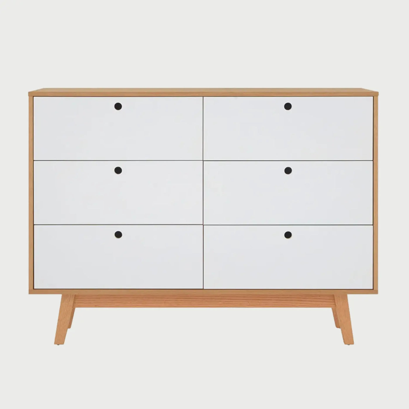 Vista frontal de la cómoda Evo de gran formato con estructura de madera clara y seis cajones amplios en color blanco mate, organizados en dos columnas paralelas con tiradores circulares negros.