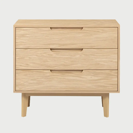 Vista frontal de la cómoda Talitha en acabado beige encino, resaltando la veta natural de la madera clara y su diseño de almacenamiento triple con estética nórdica.